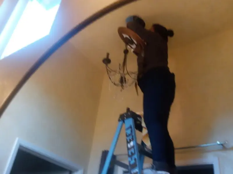 Electrician installing a chandelier in a Apache Junction residence